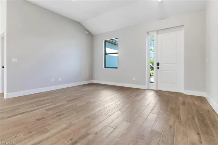 Entryway with vaulted ceiling and light hardwood / wood-style flooring