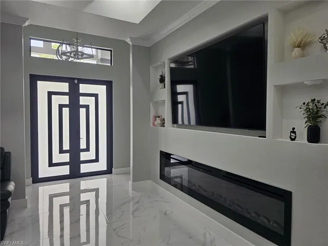 Foyer entrance with crown molding and a chandelier