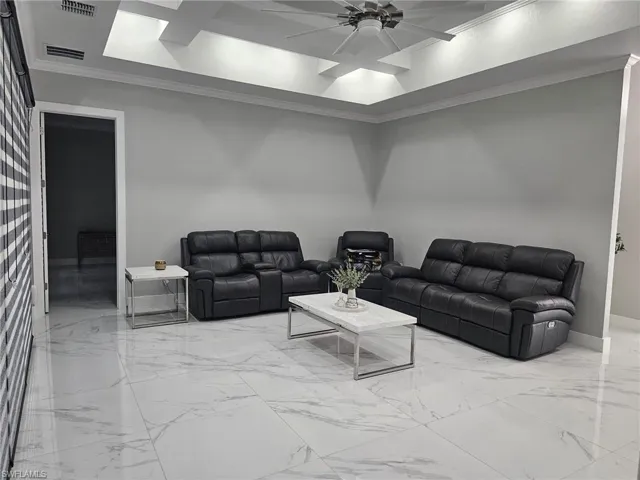Living room with ornamental molding and ceiling fan