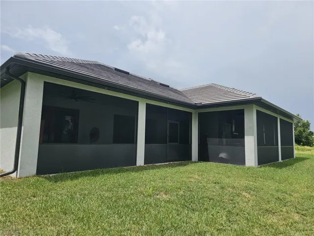 Back of house featuring a yard and a sunroom