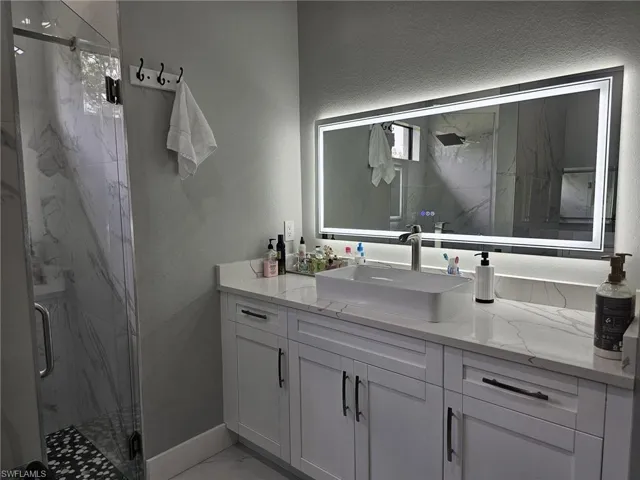 Bathroom with a shower with door and vanity