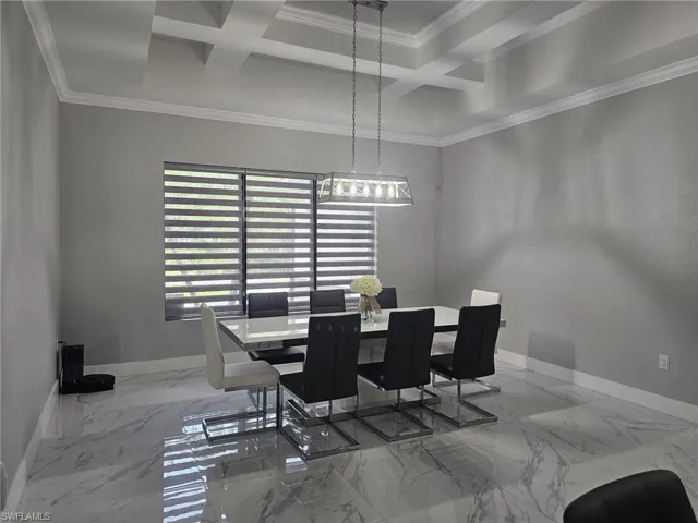 Dining space with beamed ceiling, coffered ceiling, and crown molding