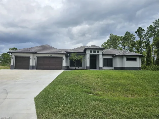 Prairie-style house featuring a garage and a front lawn