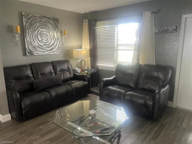 Living room with dark wood-type flooring