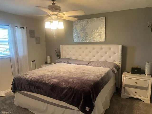 Bedroom with dark colored carpet and ceiling fan