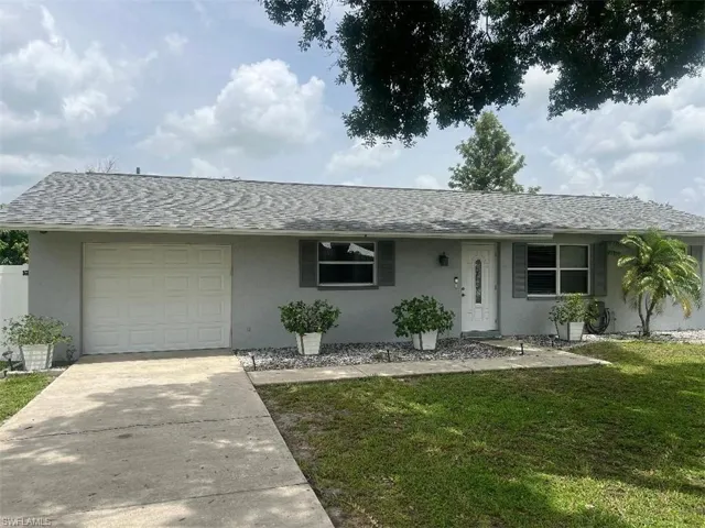Single story home featuring a garage and a front lawn