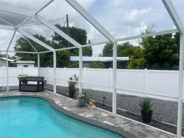 View of swimming pool featuring a patio and a lanai