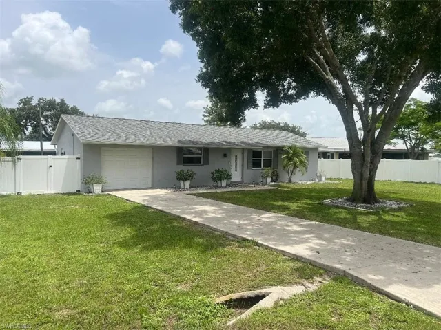 Single story home with a garage and a front yard