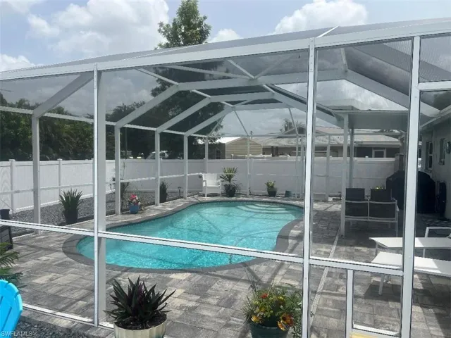 View of pool with a patio and glass enclosure