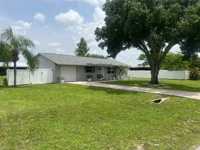 Rear view of house with a garage and a yard