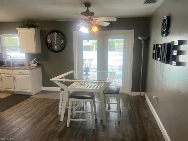 Dining area featuring sink, ceiling fan, and dark wood-type flooring