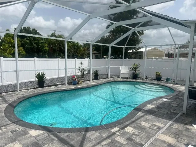 View of swimming pool featuring a patio and glass enclosure