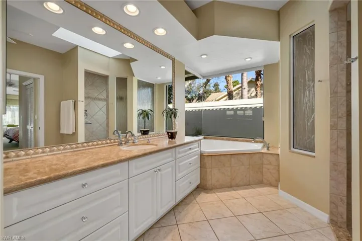 Primary bathroom has a large window that looks out to the private garden