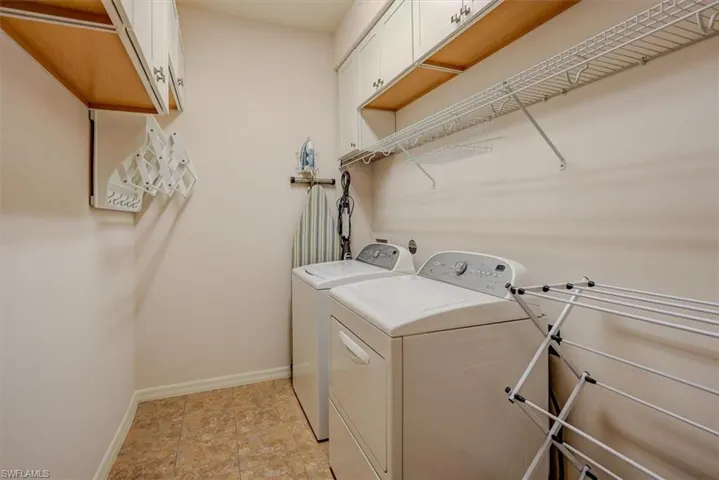 Laundry area with baseboards, cabinet space, and separate washer and dryer