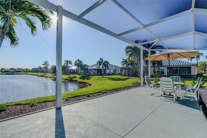 View of patio featuring glass enclosure and a water view