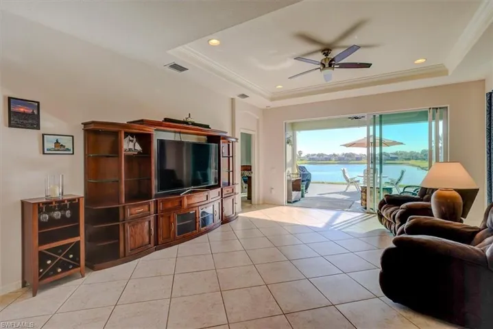 Living area tile on diagonal visible vents, crown molding, and a raised ceiling