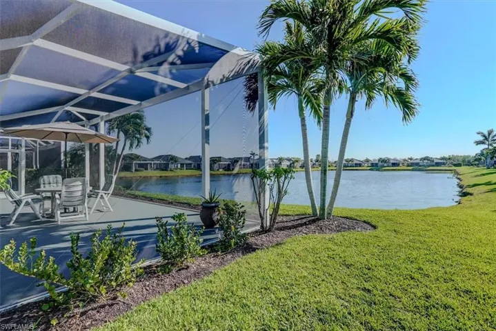 Large lot with grassy area and view of the lake
