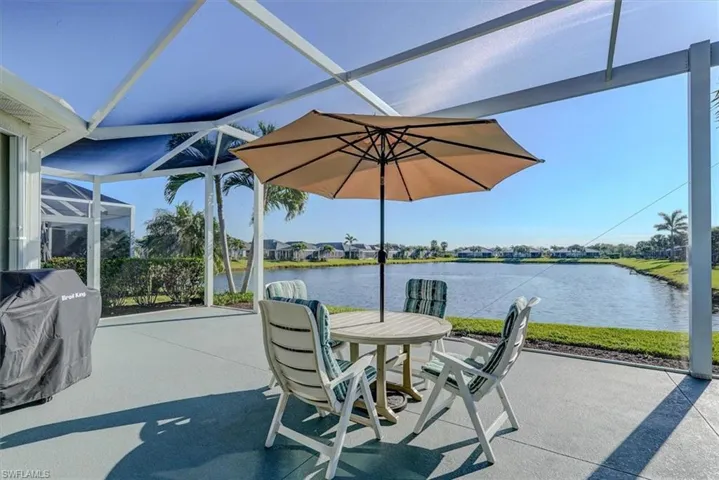 View of patio / terrace with grilling area, a water view, and a lanai