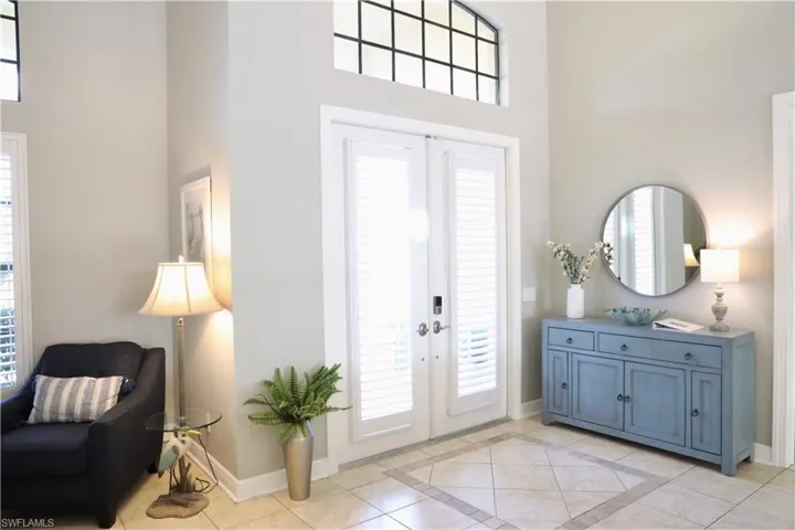 Tiled entrance foyer featuring french doors