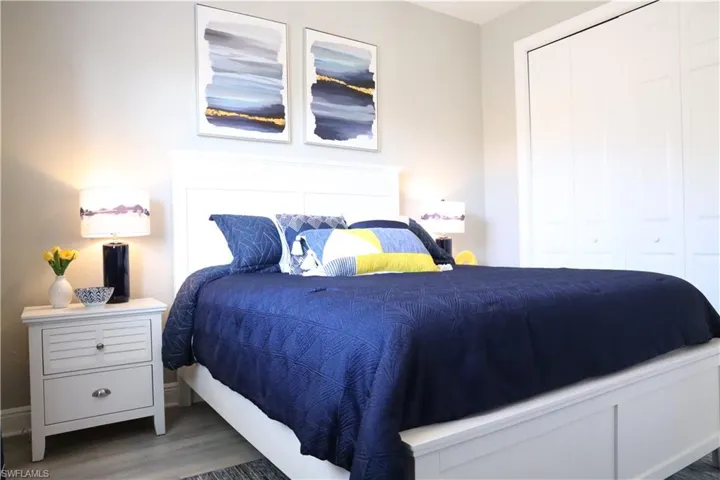 Bedroom with dark hardwood / wood-style flooring and a closet