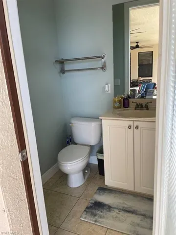 Bathroom featuring tile patterned flooring, ceiling fan, toilet, and vanity