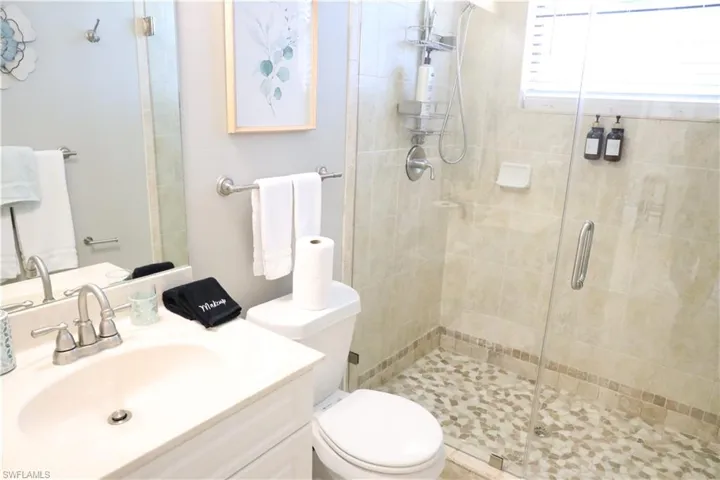 Bathroom featuring vanity, toilet, and a shower with shower door