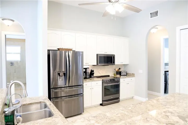 Kitchen with white cabinetry, sink, and appliances with stainless steel finishes