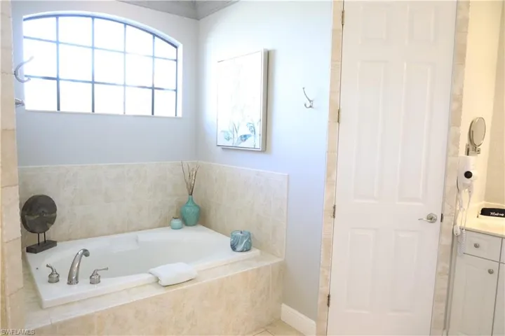 Bathroom with vanity and tiled tub