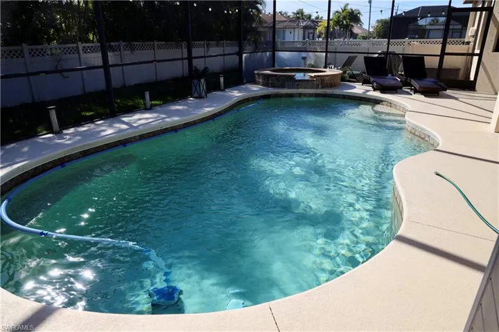 View of swimming pool with a patio area and an in ground hot tub