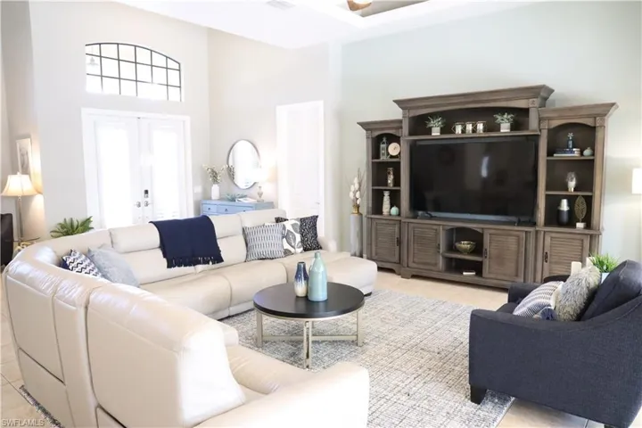 Living room featuring a towering ceiling and light tile patterned flooring