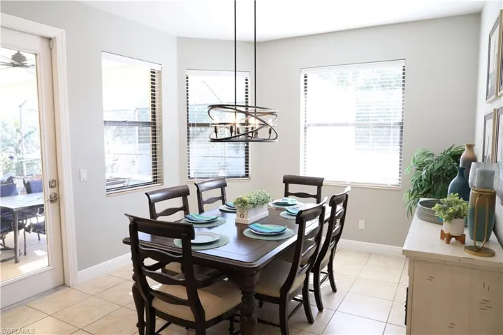 Tiled dining room with a healthy amount of sunlight and a chandelier