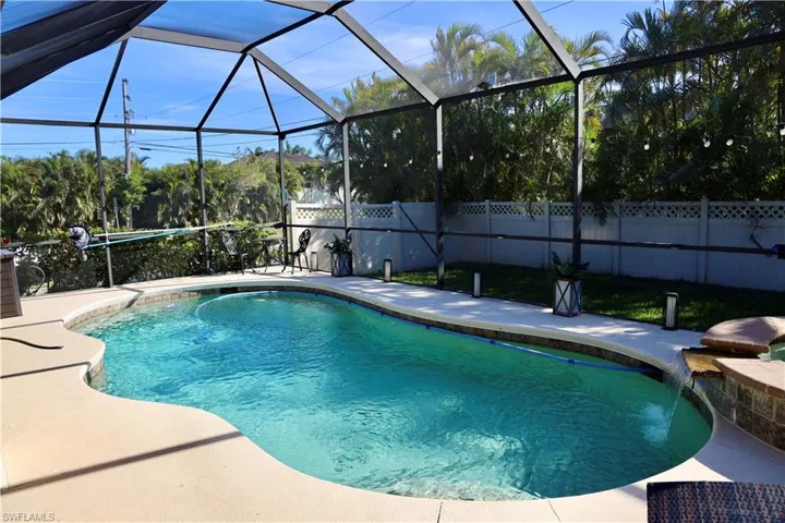 View of pool featuring pool water feature, a patio area, and a lanai
