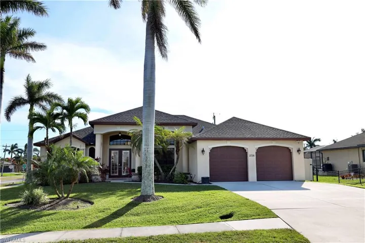 Mediterranean / spanish house with french doors, a front yard, and a garage