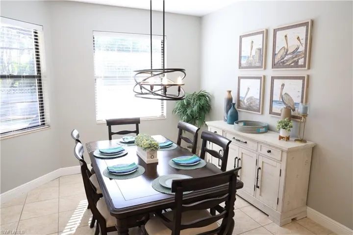Tiled dining area featuring plenty of natural light and a notable chandelier