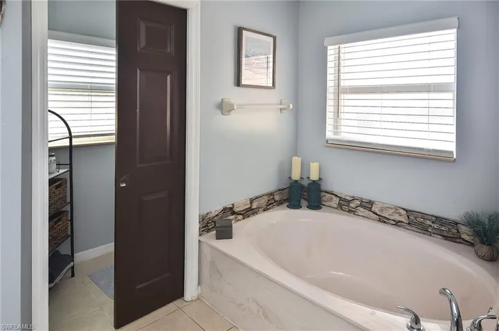 Full bathroom with a bath and light tile patterned flooring