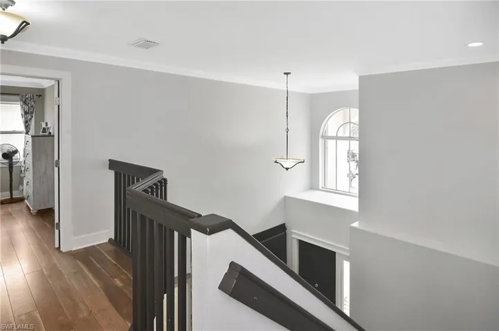 Corridor featuring crown molding, an upstairs landing, and dark wood-style flooring