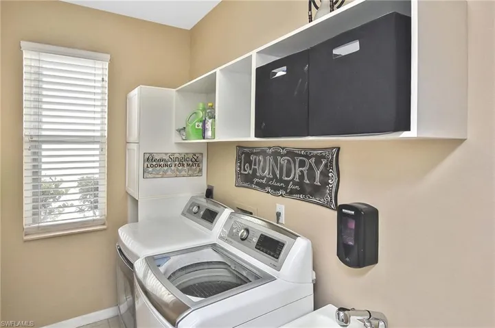 Laundry room featuring independent washer and dryer and cabinet space