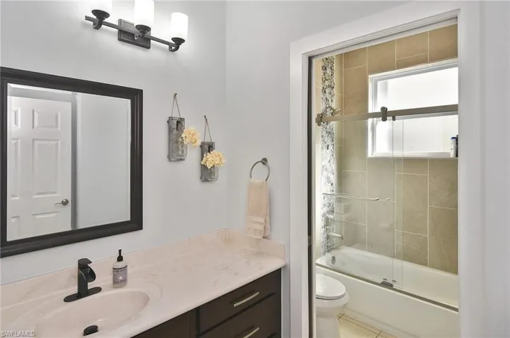 Full bath featuring vanity and enclosed tub / shower combo