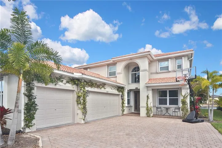 Mediterranean / spanish house with a garage, decorative driveway, stucco siding, and a tiled roof