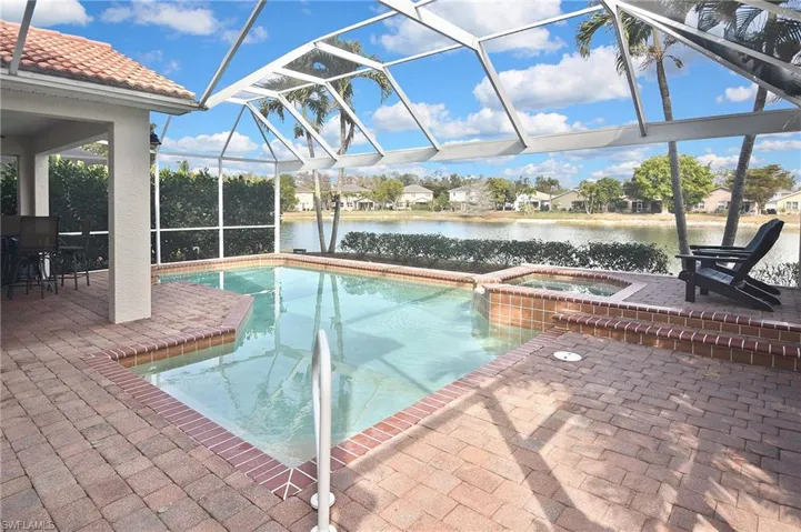 Integrated pool / spa featuring a patio, a sunroom, a residential view, a lanai, and a water view