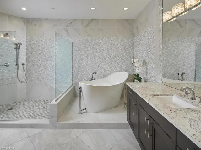 Bathroom with vanity, plus walk in shower, and tile walls