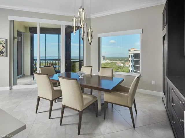 Tiled dining room with an inviting chandelier and crown molding