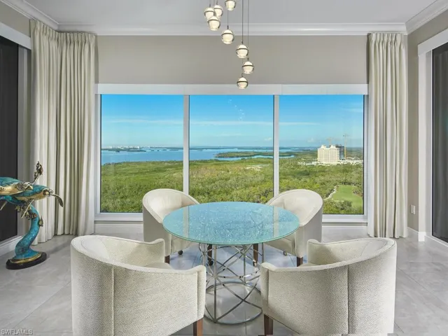 Dining space with crown molding and a water view