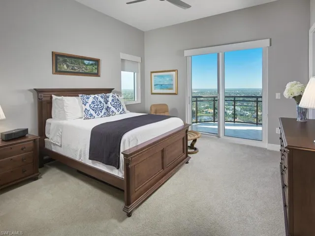 Bedroom with access to exterior, light colored carpet, and ceiling fan