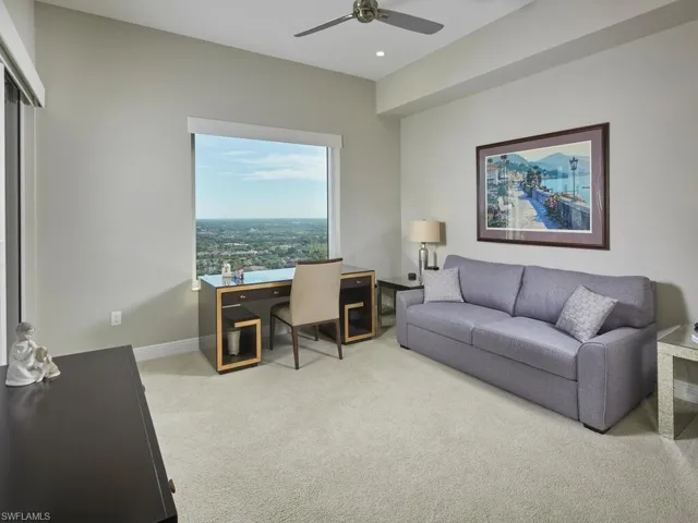 Carpeted office space featuring ceiling fan