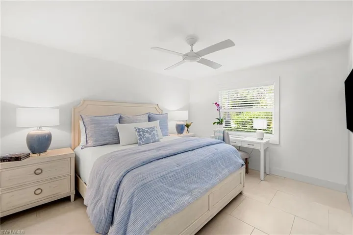 Primary Bedroom with smart TV, luxurious bedding has room for desk and seating.  Bath is en suite