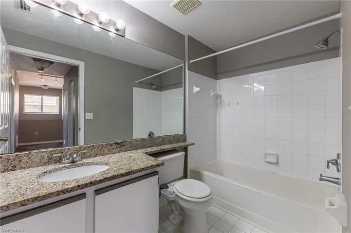Bathroom with vanity, shower / bathtub combination, toilet, and tile patterned floors