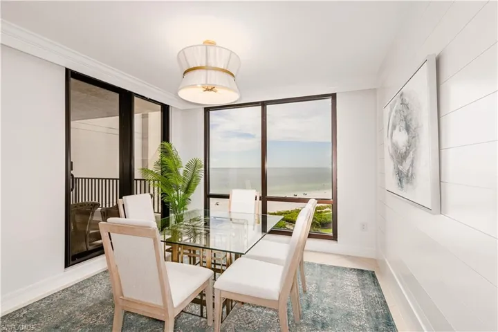 Dining space featuring tile patterned flooring, crown molding, and a water view