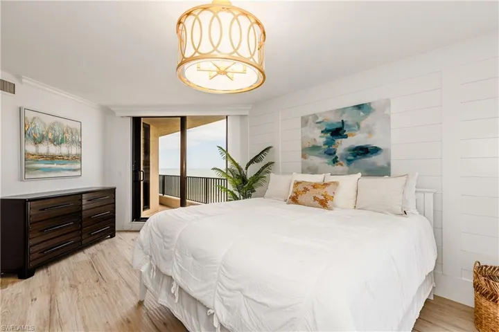 Bedroom featuring light hardwood / wood-style floors, ornamental molding, and access to outside