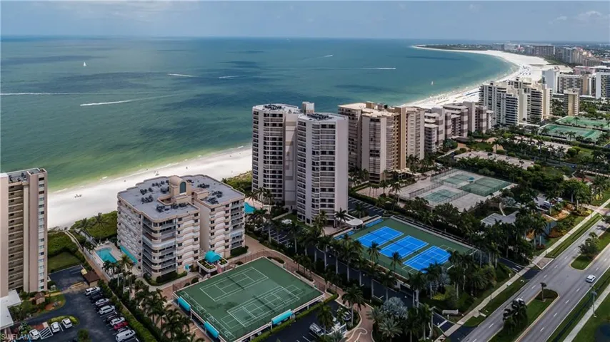 Birds eye view of property featuring a water view and a beach view